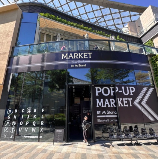 M Stand's Guangzhou pop-up store focuses on merchandise, with coffee given as a freebie, sparking discussions about brand positioning